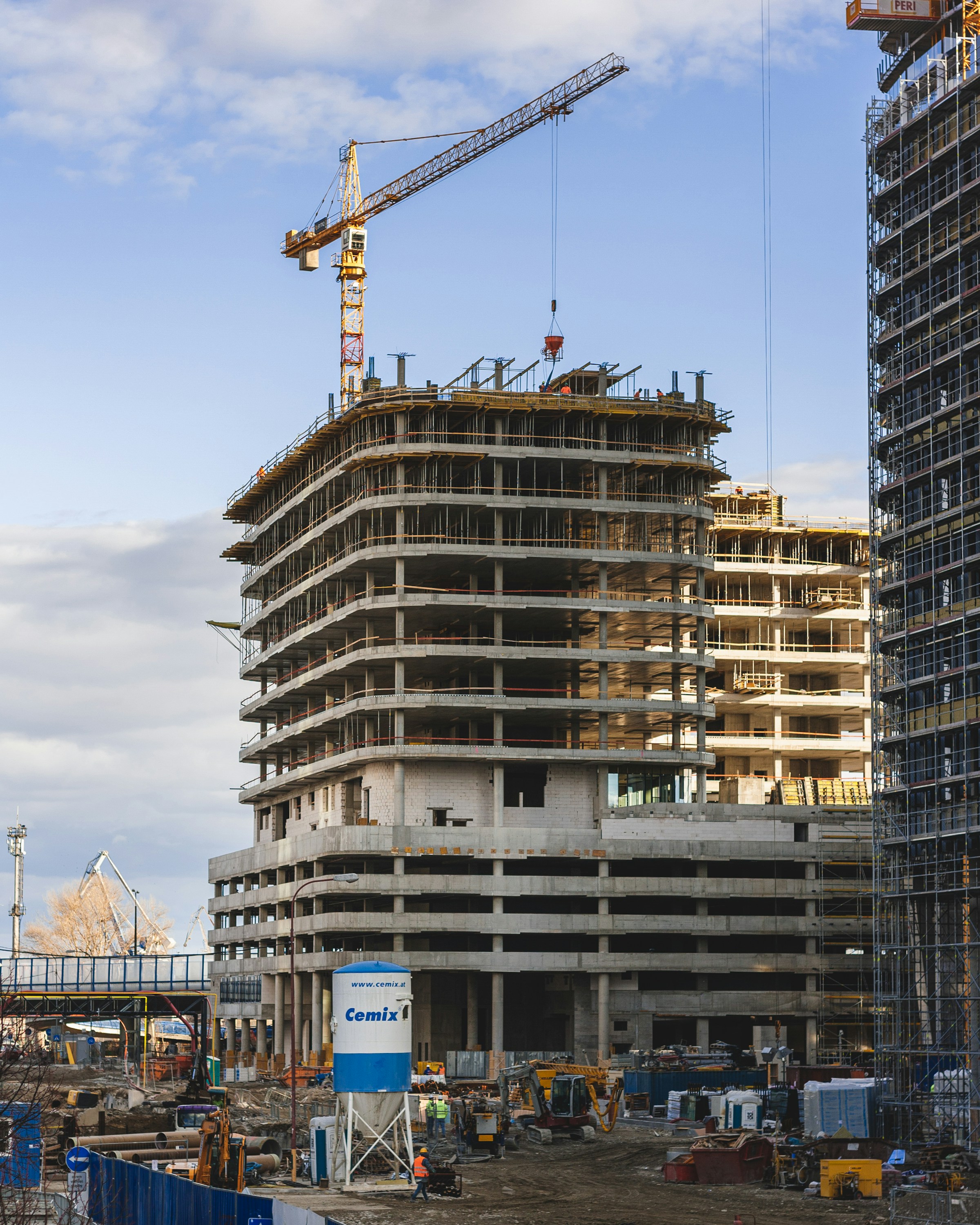 Betonrohbau mit Baukran vor blauem Himmel